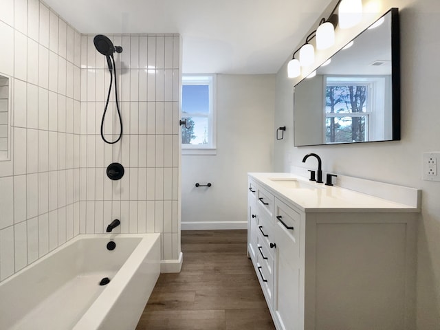 bathroom featuring hardwood / wood-style floors, vanity, and tiled shower / bath combo