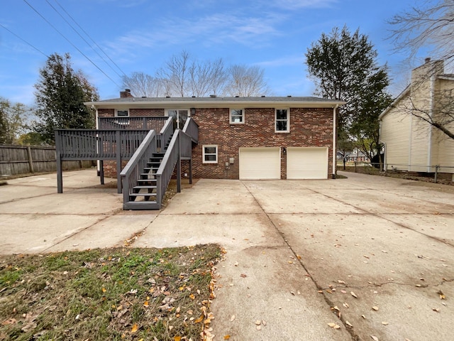 rear view of house featuring a garage and a deck