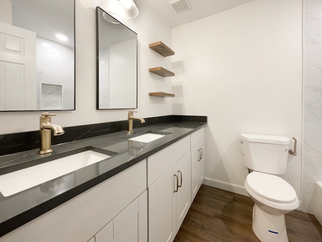 bathroom featuring toilet, vanity, and hardwood / wood-style flooring