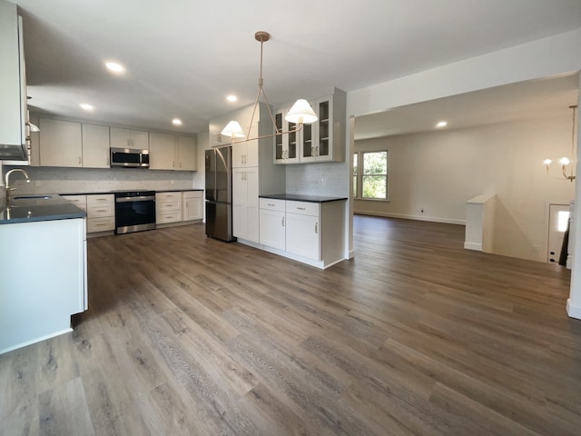 kitchen featuring decorative light fixtures, dark hardwood / wood-style floors, white cabinetry, and stainless steel appliances