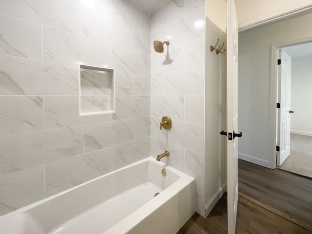 bathroom featuring wood-type flooring and tiled shower / bath