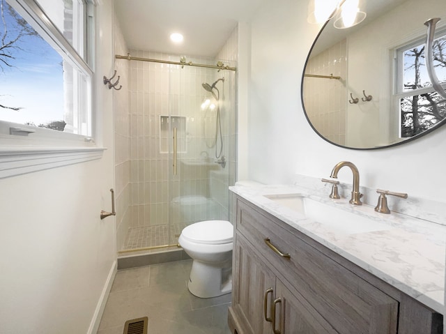 bathroom with tile patterned flooring, vanity, toilet, and walk in shower