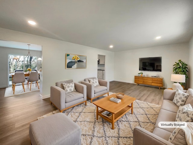 living room with hardwood / wood-style flooring and an inviting chandelier