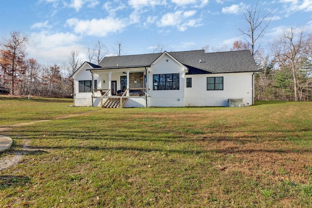 rear view of property with a lawn, a sunroom, cooling unit, and ceiling fan