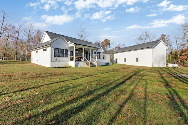 back of property featuring a porch and a lawn