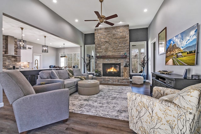 living room featuring a fireplace, dark hardwood / wood-style flooring, ceiling fan, and sink