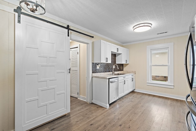 kitchen with a barn door, light wood-type flooring, white cabinetry, and stainless steel appliances