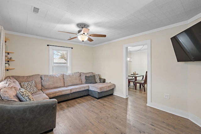 living room featuring hardwood / wood-style floors, ceiling fan, and ornamental molding