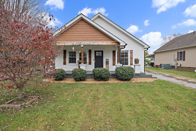 bungalow-style home featuring covered porch and a front lawn