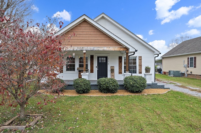 bungalow featuring a front yard and central AC unit