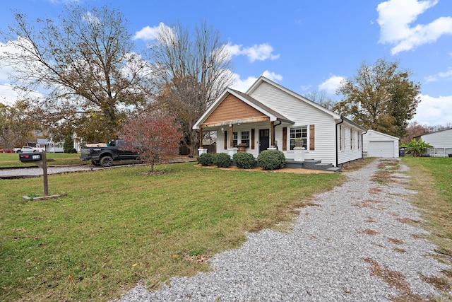 view of front facade with a front yard, a porch, an outbuilding, and a garage