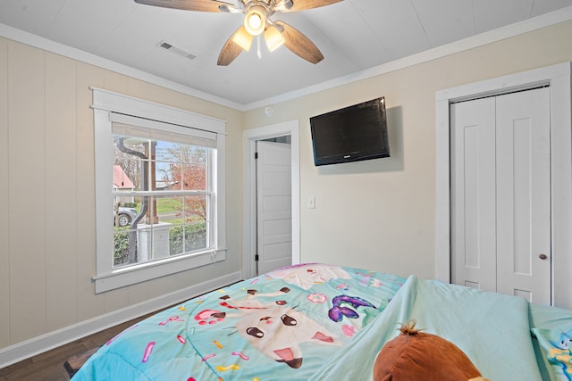 bedroom featuring a closet, ceiling fan, crown molding, and dark hardwood / wood-style floors