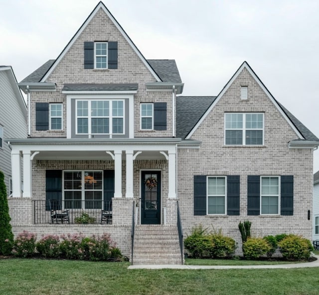 view of front facade with covered porch and a front yard