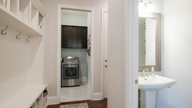 bathroom with tile patterned flooring, washer / clothes dryer, and sink