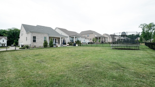 view of yard with a trampoline and a patio