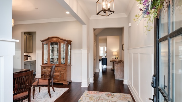 foyer with dark hardwood / wood-style flooring, a notable chandelier, and ornamental molding