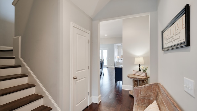 stairs featuring wood-type flooring and vaulted ceiling