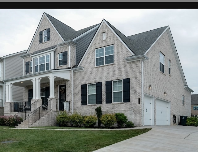 view of front facade with covered porch, a garage, and a front lawn