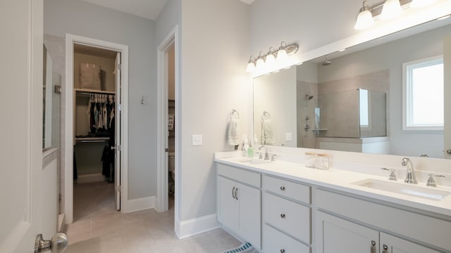 bathroom featuring a tile shower, tile patterned flooring, and vanity