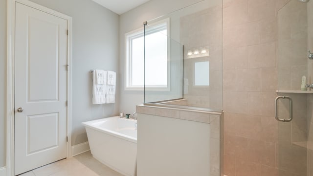 bathroom with tile patterned flooring, shower with separate bathtub, and a healthy amount of sunlight