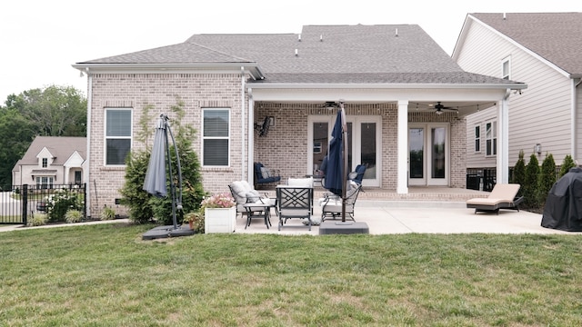 rear view of property featuring a lawn, ceiling fan, and a patio area