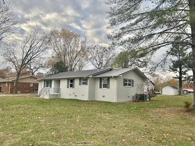 back of house with a storage unit, cooling unit, and a yard