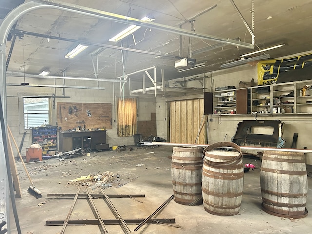 garage featuring a workshop area, electric panel, and a garage door opener