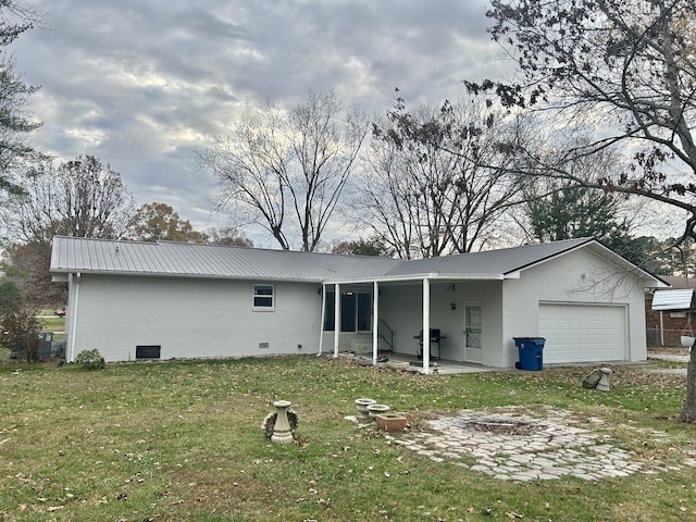 rear view of house featuring an outdoor fire pit, a yard, and a garage