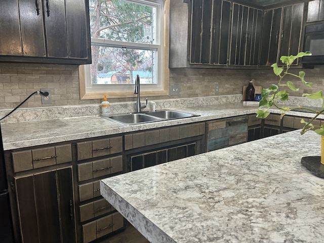 kitchen featuring backsplash, dark brown cabinetry, and sink