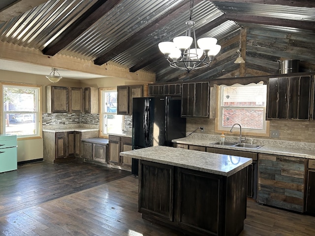 kitchen featuring decorative backsplash, vaulted ceiling, sink, decorative light fixtures, and a kitchen island