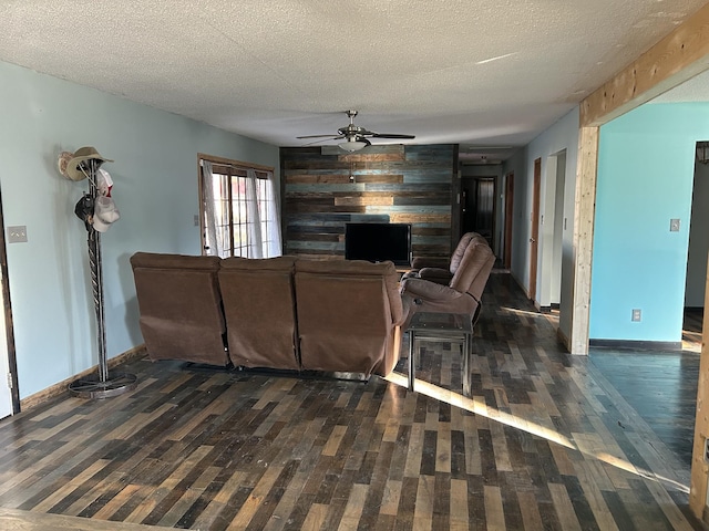 living room featuring a textured ceiling, dark hardwood / wood-style flooring, and wood walls