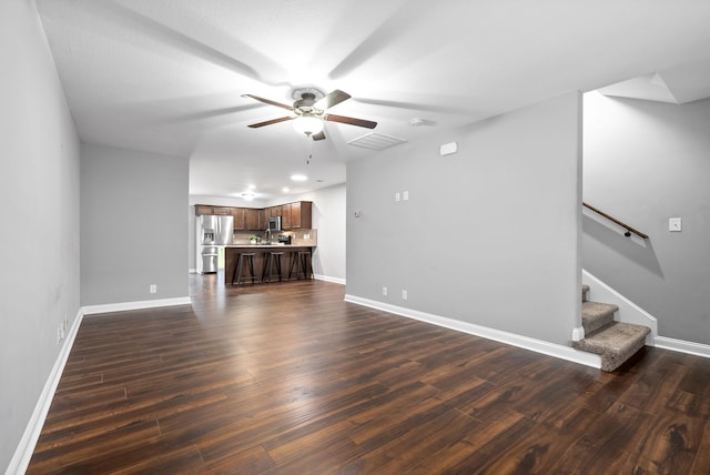 unfurnished living room featuring ceiling fan and dark hardwood / wood-style flooring