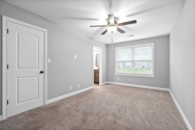 spare room with ceiling fan, light colored carpet, and a textured ceiling