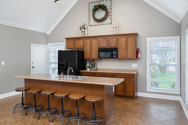 kitchen featuring a center island with sink, black appliances, plenty of natural light, and sink