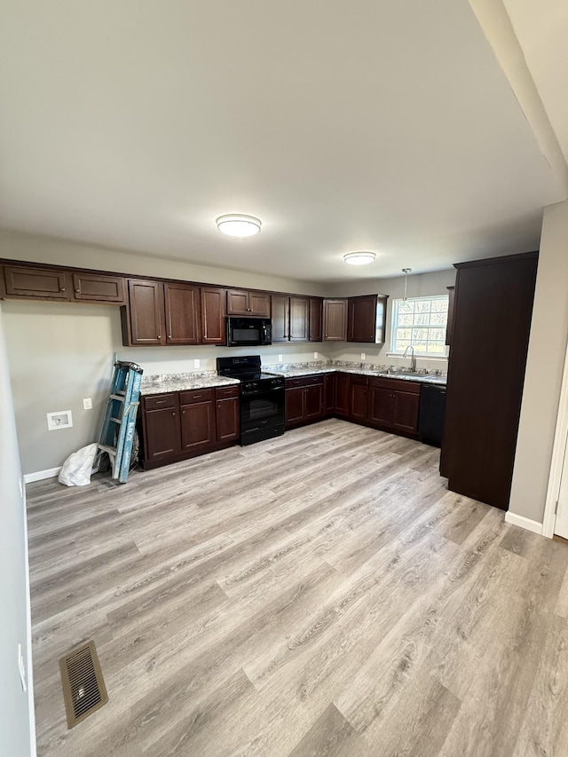 1260 Hutchins Rd, Mc Minnville, TN 37110 - kitchen with light hardwood / wood-style flooring, hanging light fixtures, dark brown cabinets, and black appliances