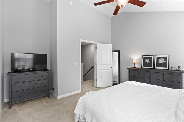 bedroom with high vaulted ceiling, ceiling fan, and light carpet