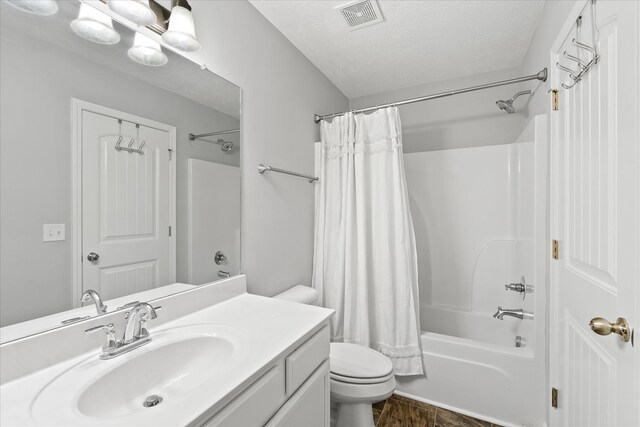 full bathroom with a textured ceiling, toilet, vanity, and shower / bath combo