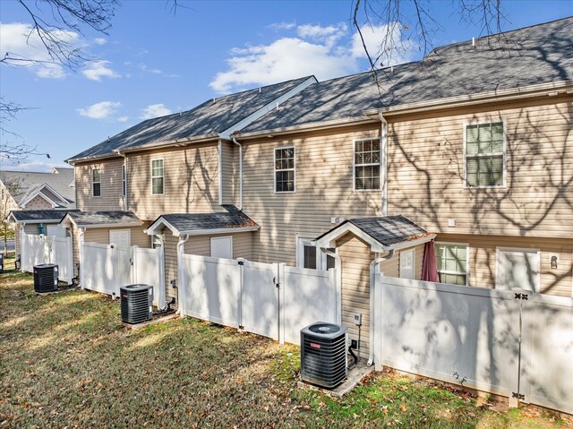 rear view of house with a yard and central AC unit