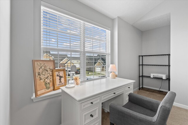 carpeted home office featuring lofted ceiling