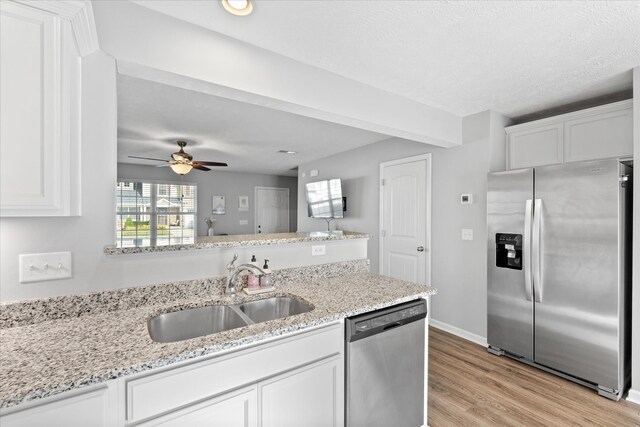 kitchen with appliances with stainless steel finishes, ceiling fan, white cabinetry, and sink