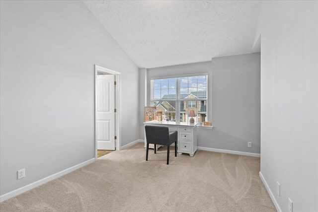 office featuring light colored carpet, vaulted ceiling, and a textured ceiling