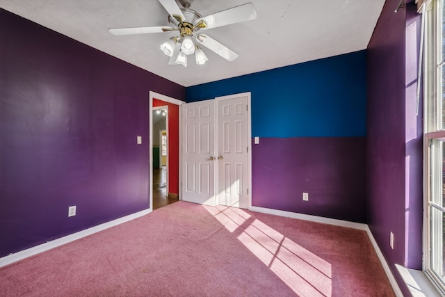 unfurnished room with ceiling fan, plenty of natural light, and light carpet