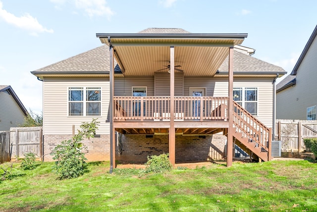 back of property with a lawn, a wooden deck, and ceiling fan