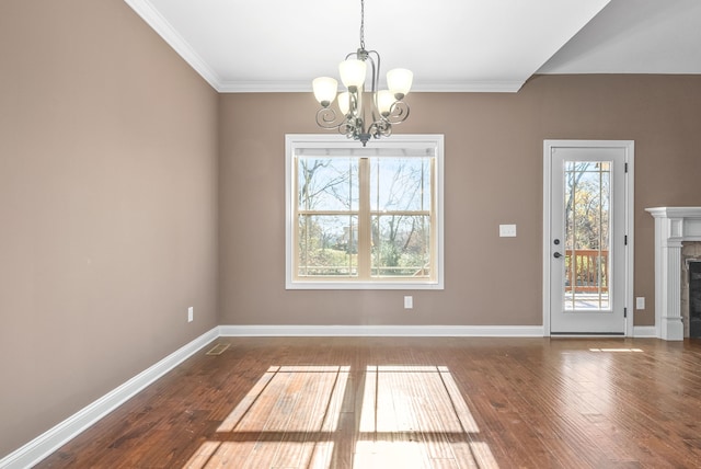 unfurnished dining area featuring ornamental molding, hardwood / wood-style floors, a healthy amount of sunlight, and a notable chandelier