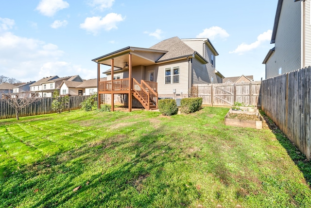 back of house featuring a wooden deck and a yard