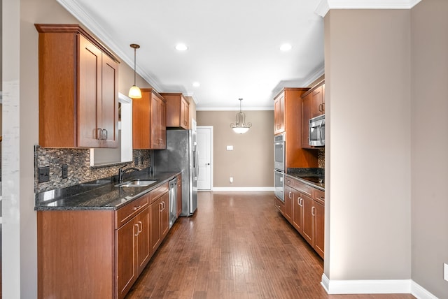 kitchen featuring decorative light fixtures, dark hardwood / wood-style flooring, sink, and appliances with stainless steel finishes