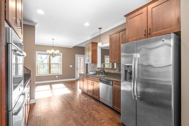 kitchen featuring pendant lighting, sink, a notable chandelier, dark hardwood / wood-style flooring, and stainless steel appliances