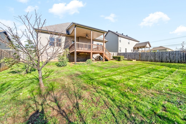 back of house with ceiling fan, a lawn, and a wooden deck