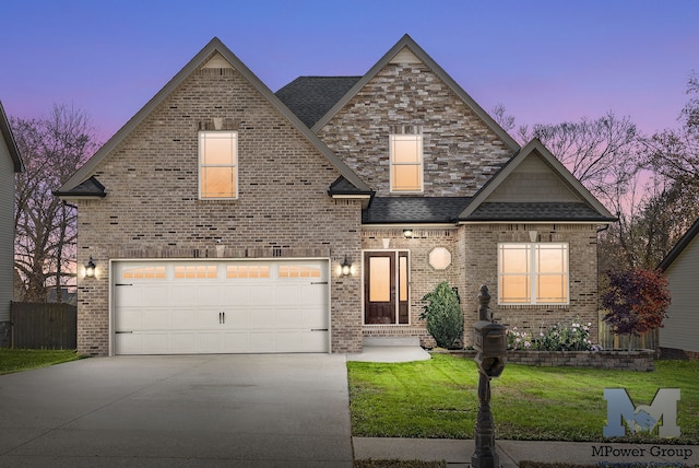 view of front of home with a yard and a garage