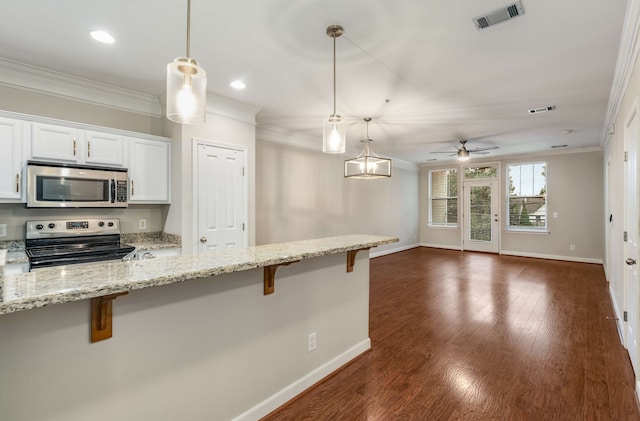 kitchen featuring hanging light fixtures, a breakfast bar area, ceiling fan, white cabinetry, and stainless steel appliances